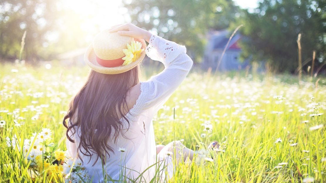 Young woman sitting and sun is shining.